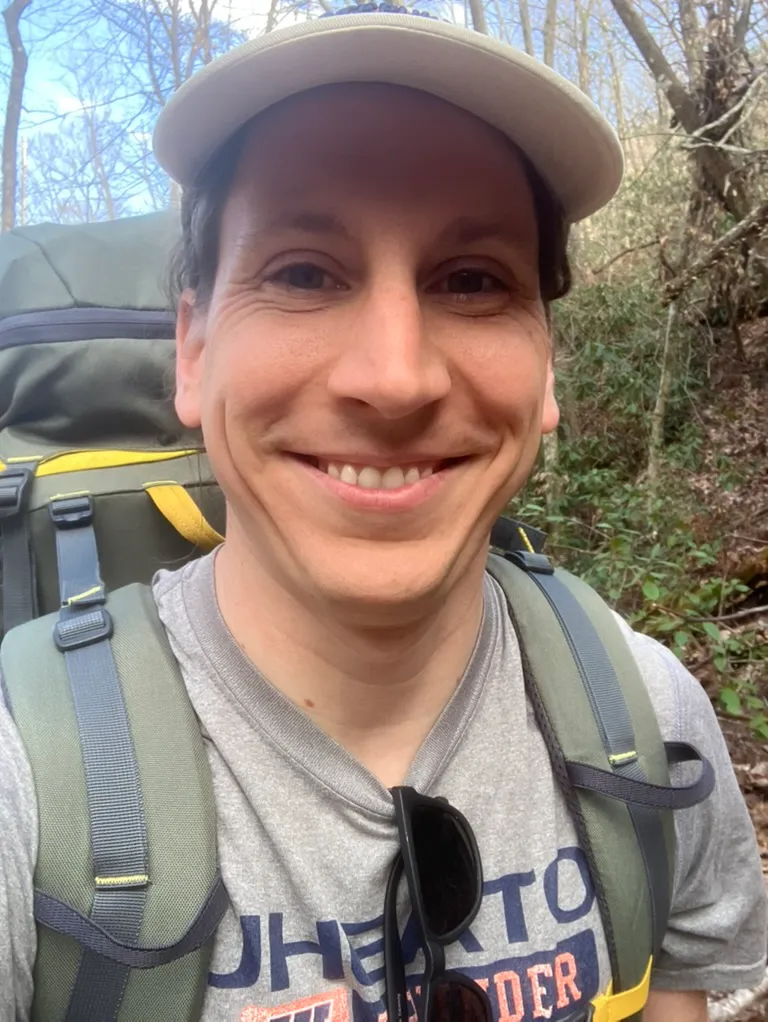 A portrait of Ben backpacking in the mountains